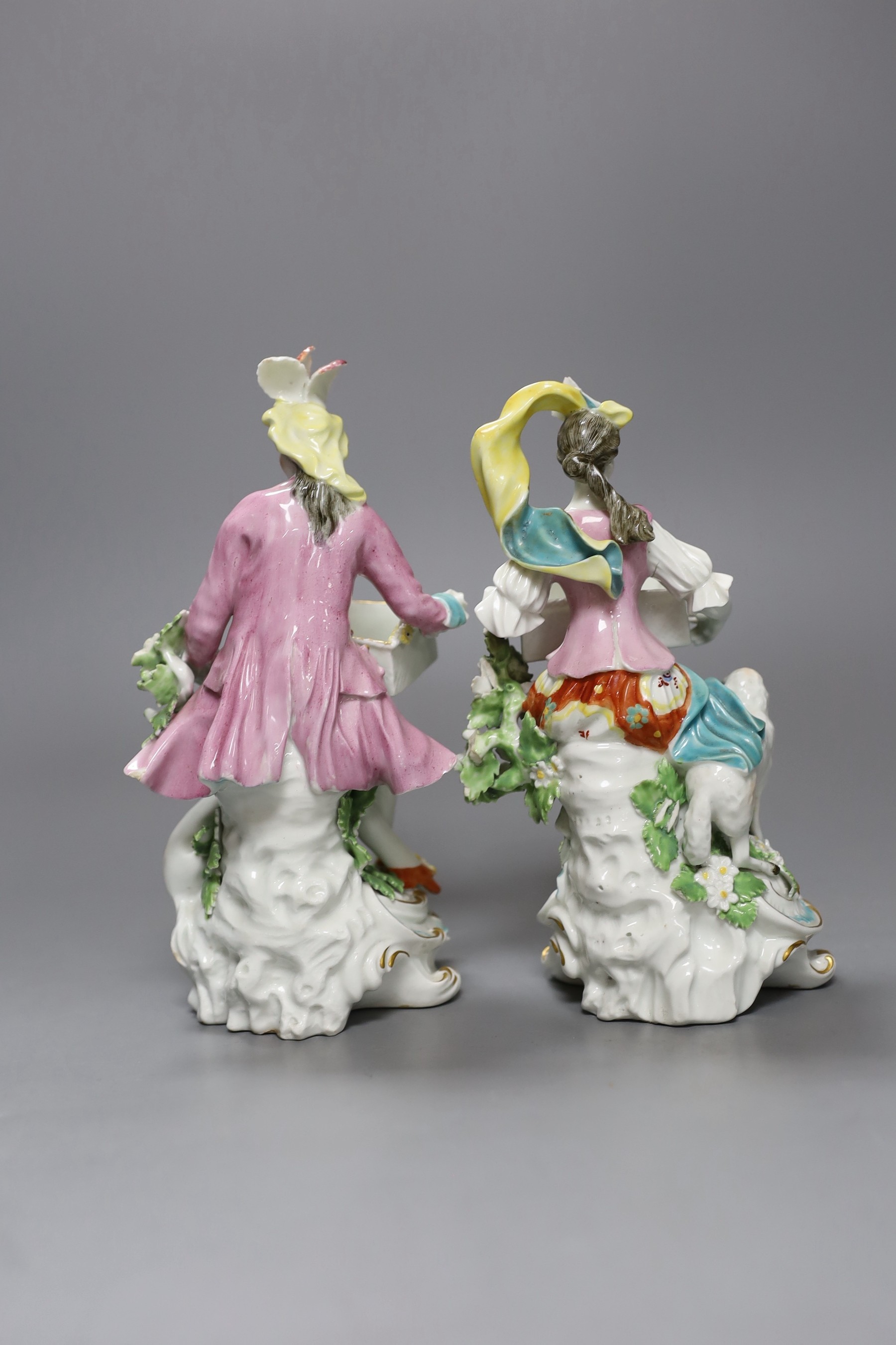Two Derby sweetmeat figures, each seated and resting with an open rectangular basket on their knees, c.1760-65, patch marks, 20cm